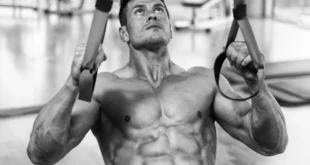 Bodybuilder trainiert hintere Schulter mit Sling Trainer
